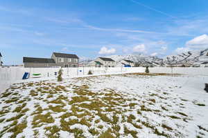 Yard covered in snow featuring a mountain view