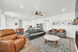 Living room with ceiling fan, sink, and light hardwood / wood-style floors