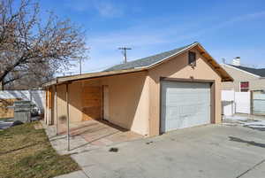 View of front of house with a garage and an outdoor structure