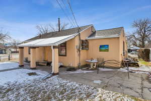 Snow covered property with a patio area