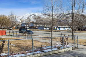 Yard covered in snow featuring a mountain view