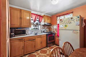 Kitchen with tasteful backsplash, appliances with stainless steel finishes, and light tile patterned floors