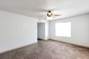 Empty room featuring carpet and ceiling fan