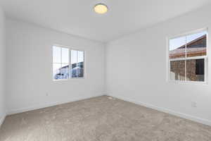 Carpeted empty room featuring a wealth of natural light