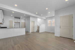 Unfurnished living room featuring light wood-type flooring and sink