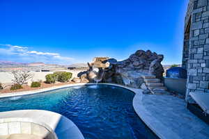 View of pool with a mountain view, a patio, and pool water feature