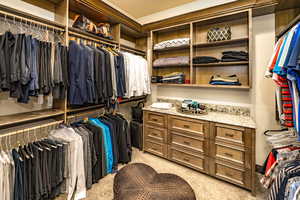 Walk in closet featuring light colored carpet