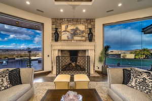 Living room featuring a raised ceiling, dark hardwood / wood flooring, and a fireplace