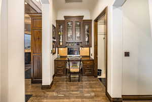 Home office with built in desk and dark hardwood / wood-style floors