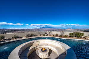 View of pool with a mountain view and an outdoor fire pit