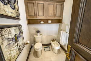 Bathroom featuring a bidet, toilet, and tile patterned floors