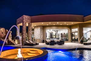 Pool at twilight with a patio and an outdoor living space with a fire pit