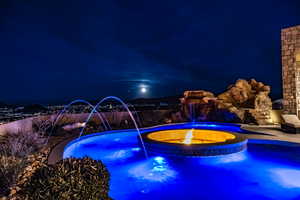 Pool at night with pool water feature