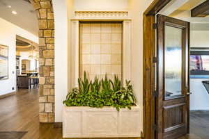 Interior space featuring water feature and lush planter box outside of the home office dark wood-type flooring