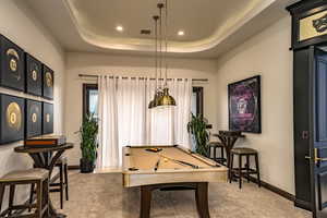 Game room featuring a tray ceiling, pool table, and carpet floors