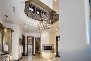 Living room with a fireplace, sink, and a notable chandelier