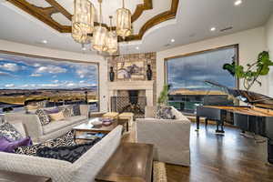 Living room with sweeping views of St. George and Washington, a chandelier, a stone fireplace, and wood flooring