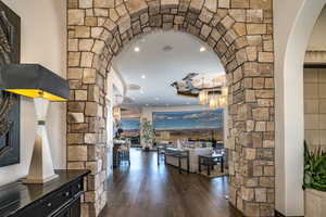 Corridor featuring dark wood flooring and ornate stone columns