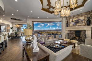 Living room featuring a large fireplace, an inviting chandelier, and dark hardwood / wood floors