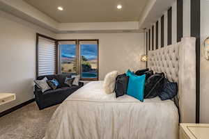 Bedroom with carpet flooring and a raised ceiling