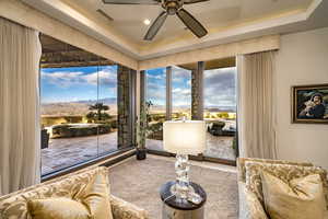 Living area with a tray ceiling and ceiling fan