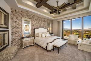 Bedroom featuring access to outside, beam ceiling, brick wall, coffered ceiling, and carpet flooring