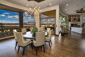 Dining space featuring a tray ceiling, a large fireplace, and dark hardwood / wood-style floors