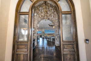 Corridor with dark parquet flooring and a beautiful chandelier