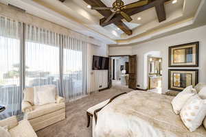 Bedroom featuring connected bathroom, a raised ceiling, coffered ceiling, beamed ceiling, and carpet flooring