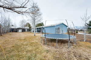 View of yard featuring a storage unit, a trampoline, and a mountain view