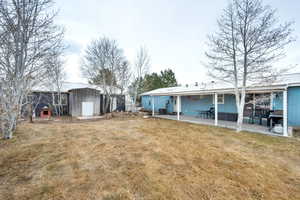 View of yard featuring a storage unit and a patio