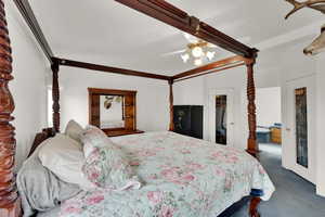 Bedroom with a closet, a spacious closet, dark colored carpet, and ceiling fan