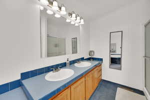 Bathroom featuring ornamental molding, vanity, and a shower with door