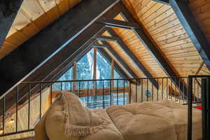 Interior space featuring wood walls, wooden ceiling, and lofted ceiling with beams