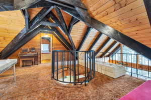 Bonus room with wood ceiling, carpet flooring, vaulted ceiling with beams, and wood walls