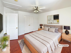 Bedroom with ceiling fan, a closet, and dark wood-type flooring