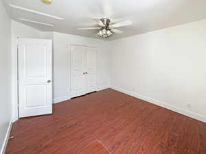 Empty room with dark wood-type flooring and ceiling fan