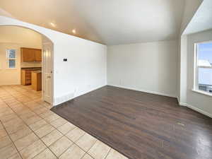 Spare room with light hardwood / wood-style floors and vaulted ceiling