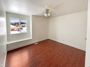 Unfurnished room featuring dark hardwood / wood-style flooring, ceiling fan, and a textured ceiling