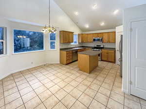 Kitchen featuring an inviting chandelier, sink, a center island, decorative light fixtures, and stainless steel appliances