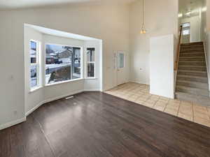 Foyer entrance with high vaulted ceiling and light hardwood / wood-style floors