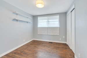 Unfurnished room featuring dark wood-type flooring