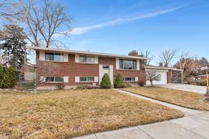 Bi-level home with a garage and a front lawn