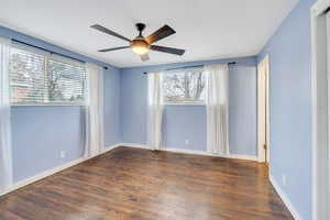 Empty room with dark hardwood / wood-style flooring and ceiling fan