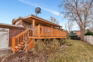 Rear view of property featuring a yard and a deck