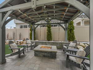 View of patio featuring an outdoor fire pit and a gazebo