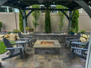 View of patio featuring an outdoor fire pit and a gazebo (Summer View)