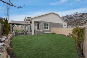 Rear view of house with a patio area, a yard, a gazebo, and a mountain view