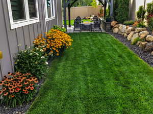 View of yard featuring a patio area and an outdoor fire pit (Summer View)