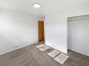 Unfurnished bedroom featuring carpet floors and a closet